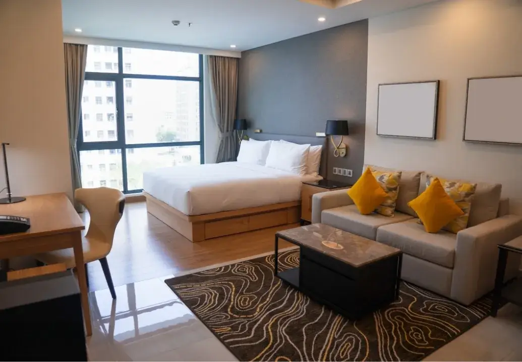 Elegant and spotless short-term rental suite with made bed, clean sofa, and tidy workspace